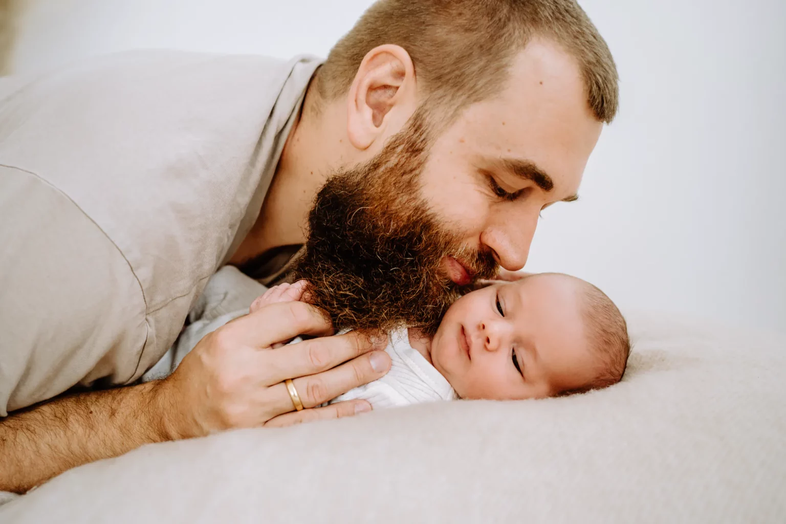 Papa küsst Sohn beim Babyfotografen