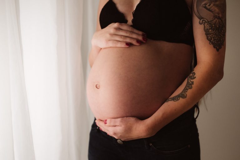 Babybauch Fotos mit Vorhang im Hintergrund zu Hause
