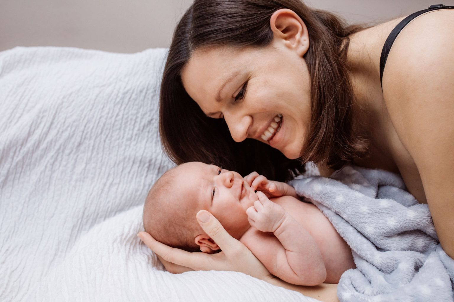 Mama und lachendes Baby beim Fotoshooting daheim