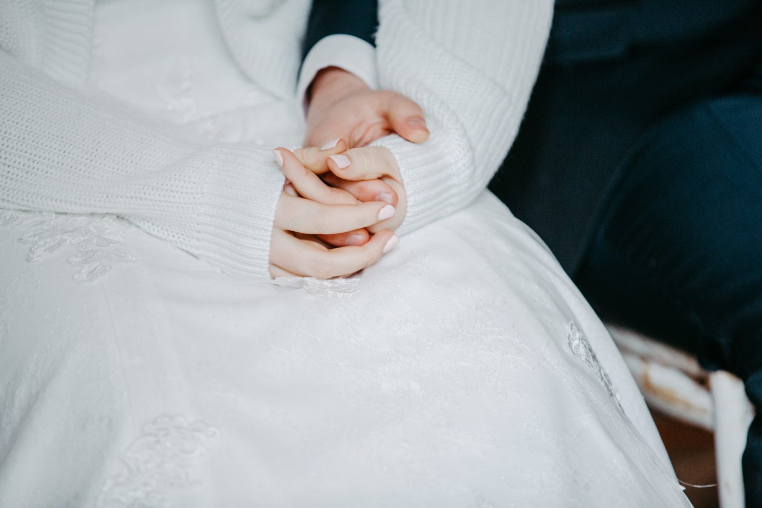 Braut und Bräutigam halten Händchen bei der Hochzeit trotz schlechtem Wetter