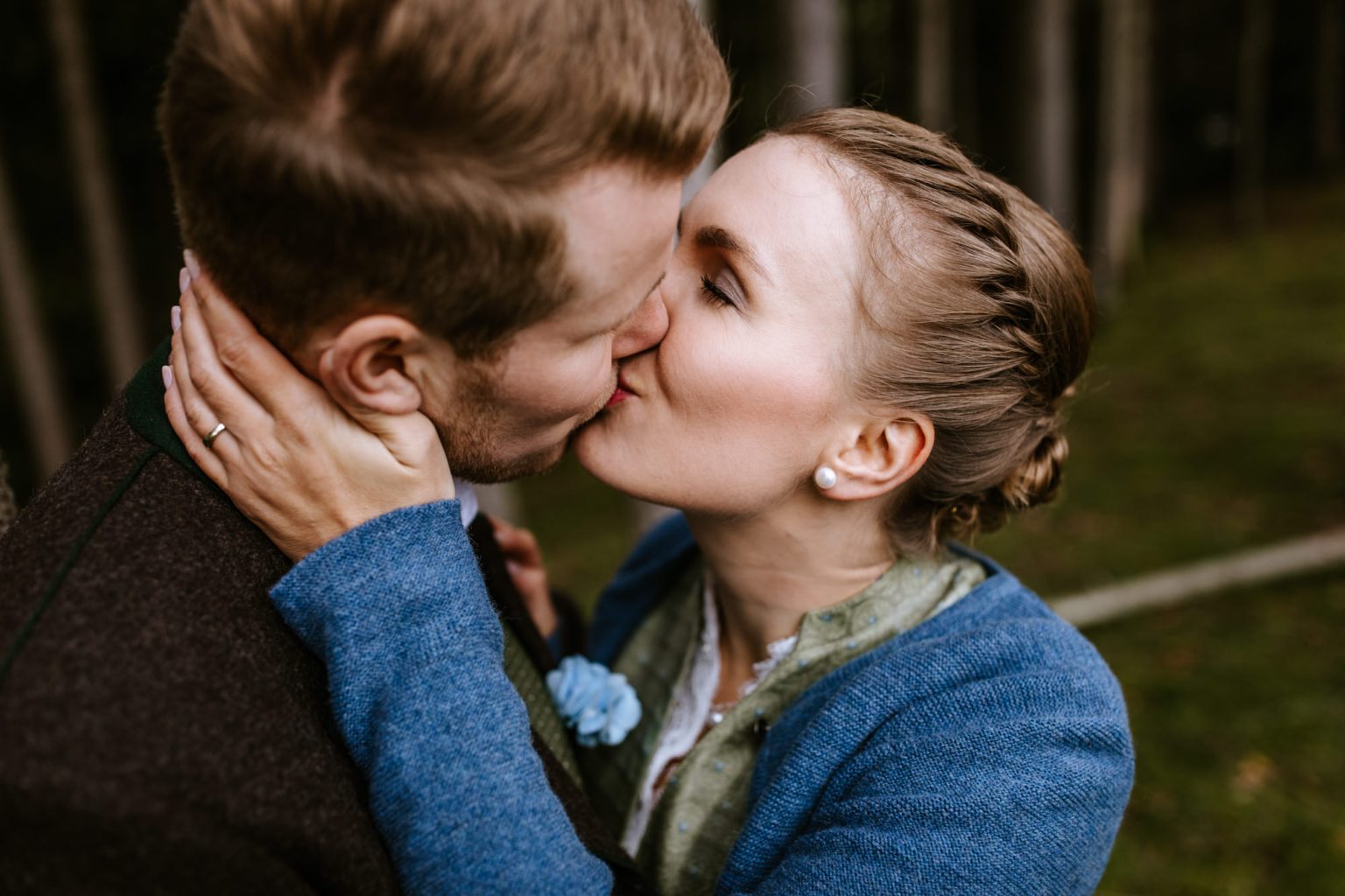 Braut in Dirndl küsst ihren zukünftigen Mann