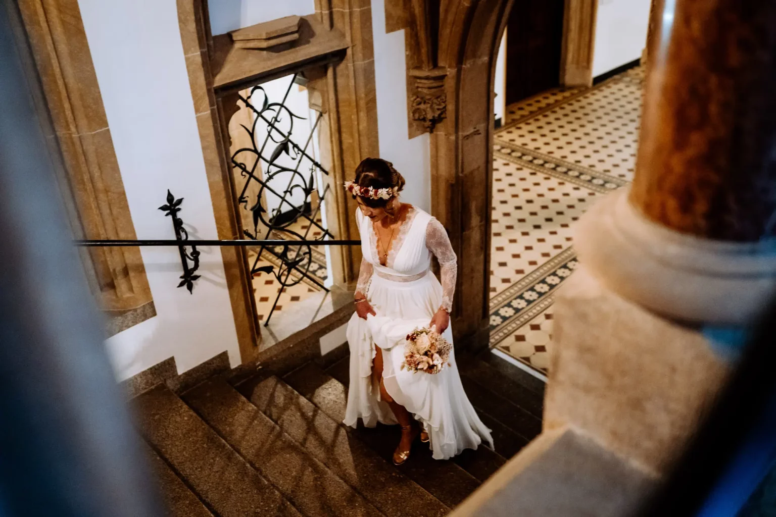 Braut läuft zu ihrem Bräutigam auf der Treppe in Münchner Rathaus am Marienplatz