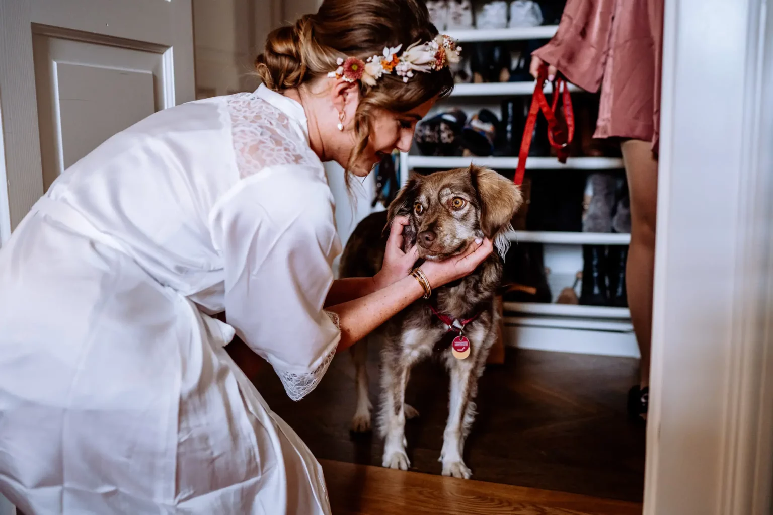 Braut streichelt ihren Hund vor der Hochzeit