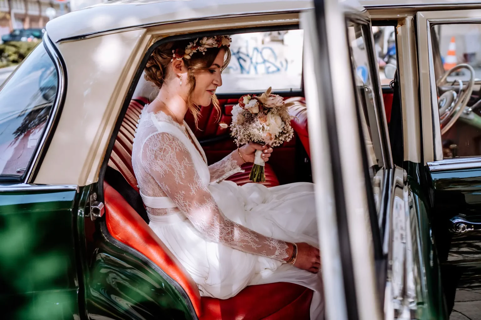 Braut steigt ins Brautauto ein vor der Hochzeit