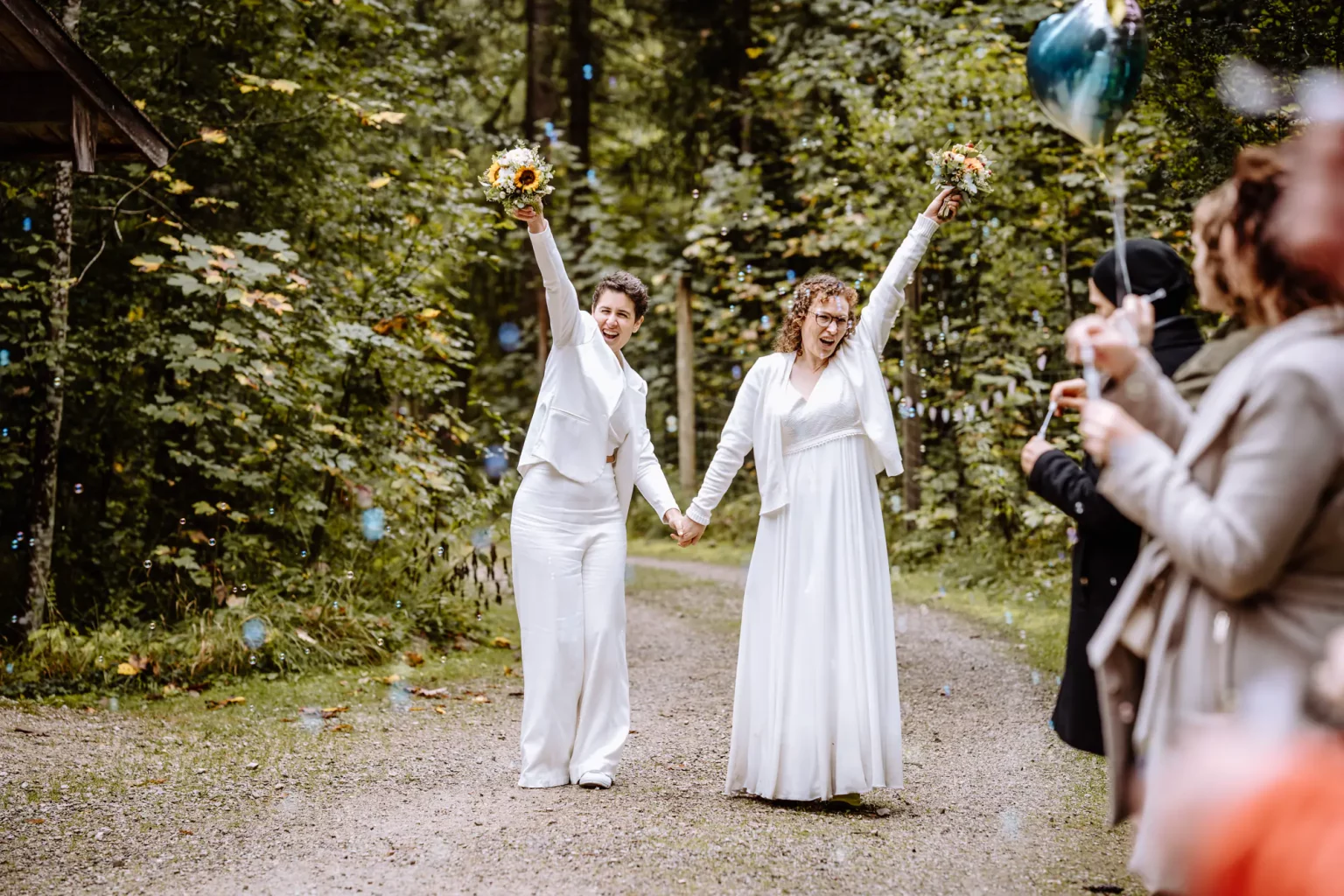 Die Bräute kommen zu ihrer freien Trauung im Wald und sind super happy